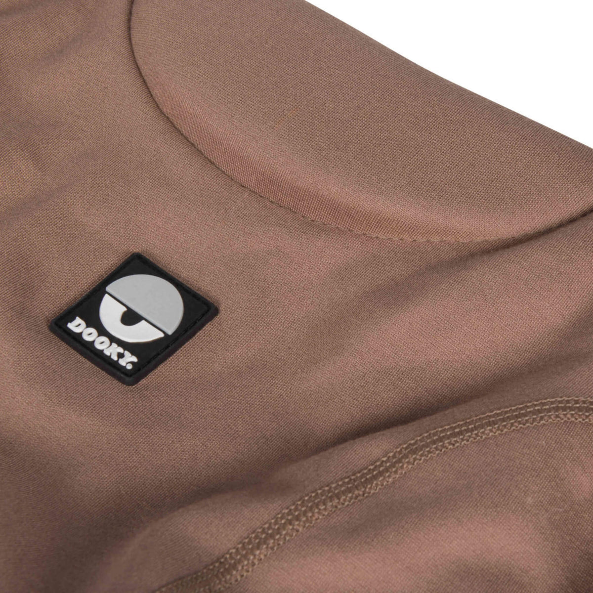 Close-up of soft mocha baby carrier fabric with padded curved neckline and visible stitched seam detailing.