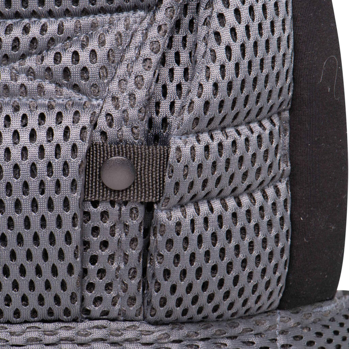 Close-up of grey mesh baby carrier fabric with adjustable press-stud fastenings.