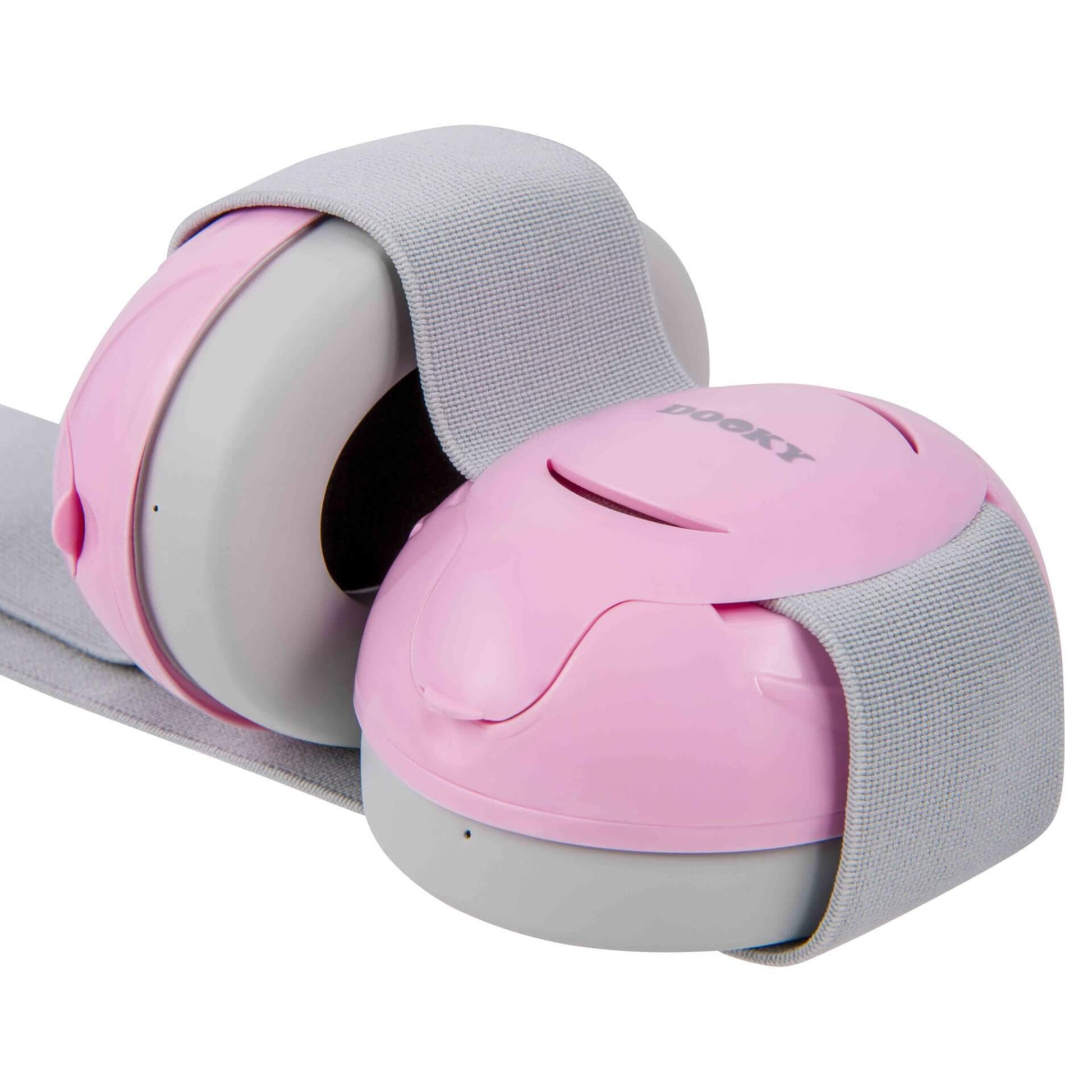 A close-up view of two baby ear defenders connected by a grey fabric band, with pink outer shells and grey cushioning on the inner side.