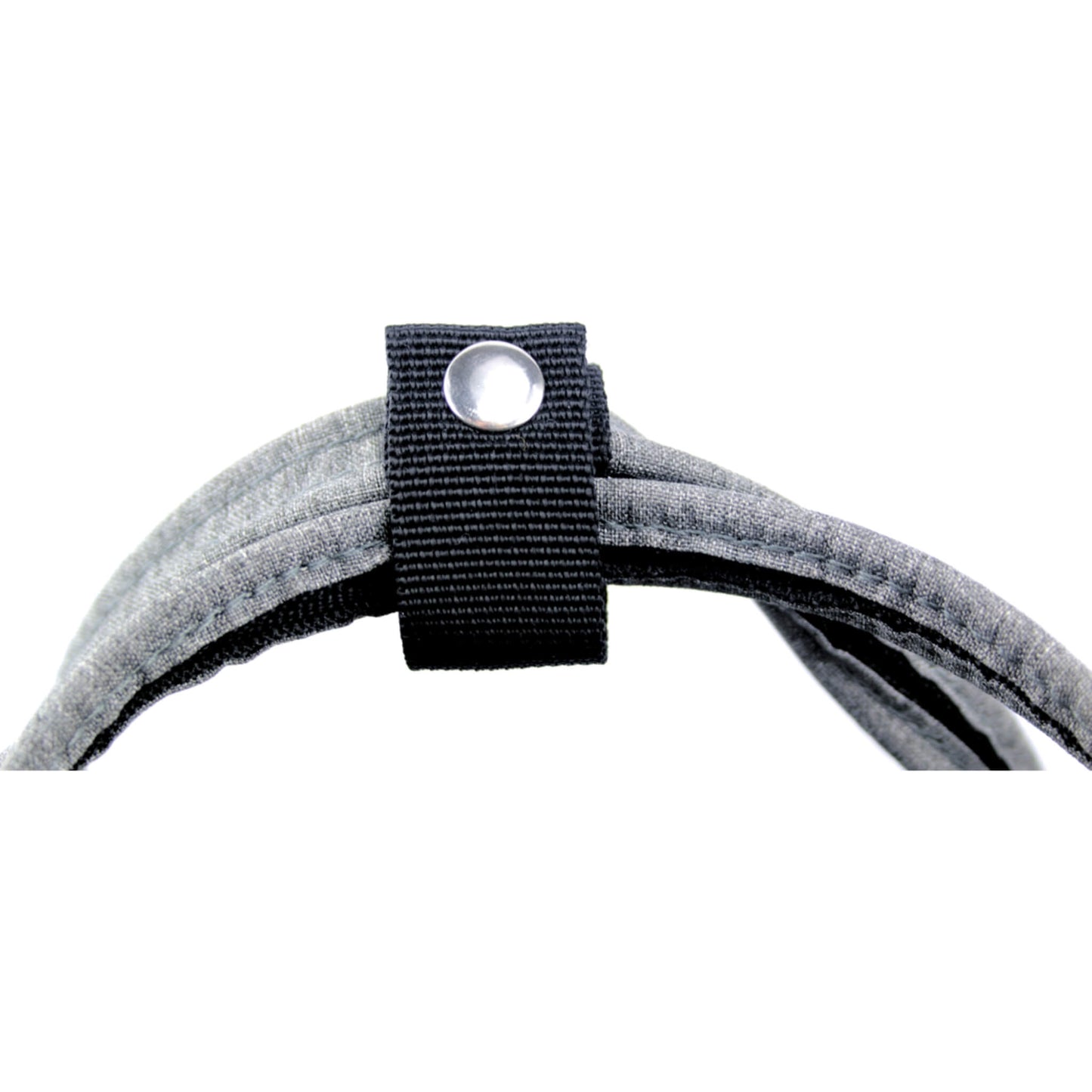 A close-up of a snap button fastening securing the two top carry handles of a fabric changing bag together.