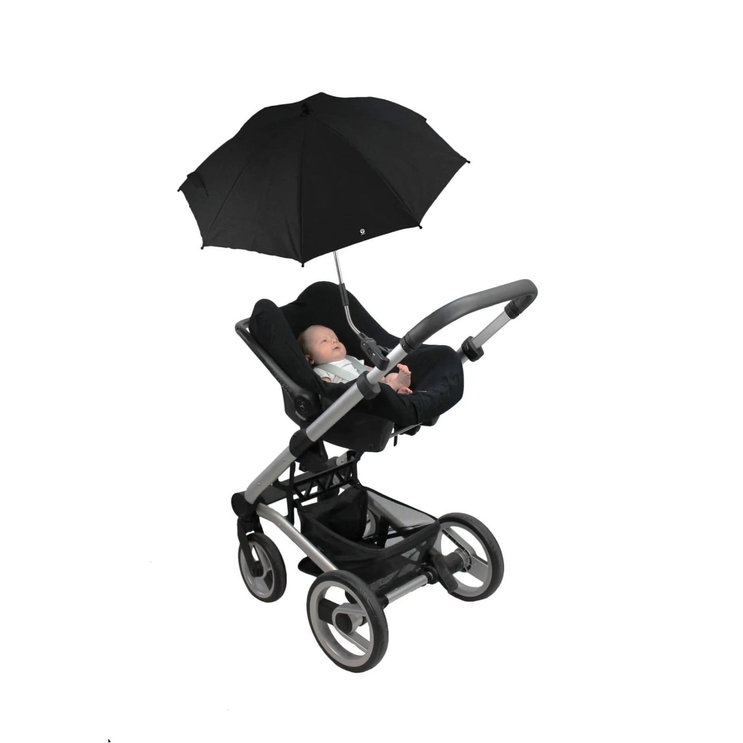 A baby lying in a rear-facing stroller seat beneath an open black parasol attached to the pushchair frame.