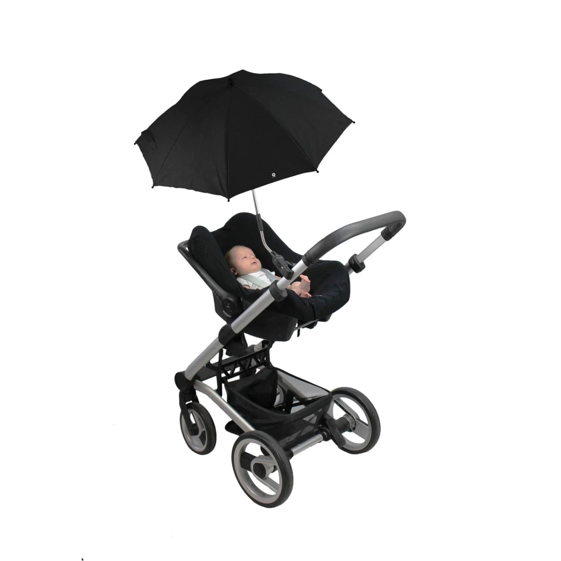 A baby lying in a rear-facing stroller seat beneath an open black parasol attached to the pushchair frame.