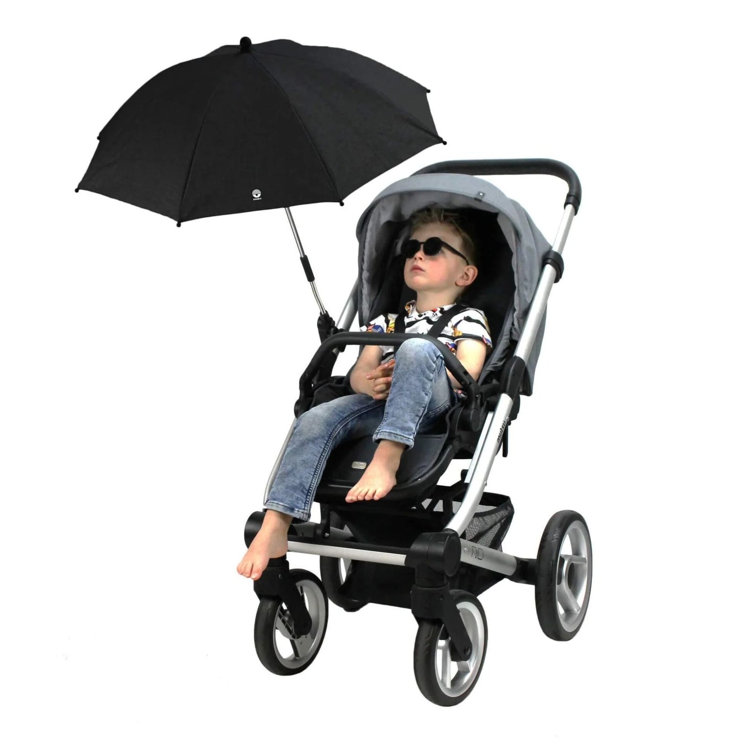 A young child sitting upright in a stroller with an overhead parasol providing shade, wearing sunglasses and relaxed.