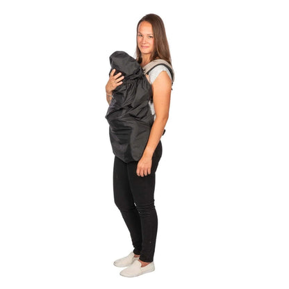 Woman holding a baby in a carrier fully covered by a black rain cape, with the hood pulled over the baby’s head.