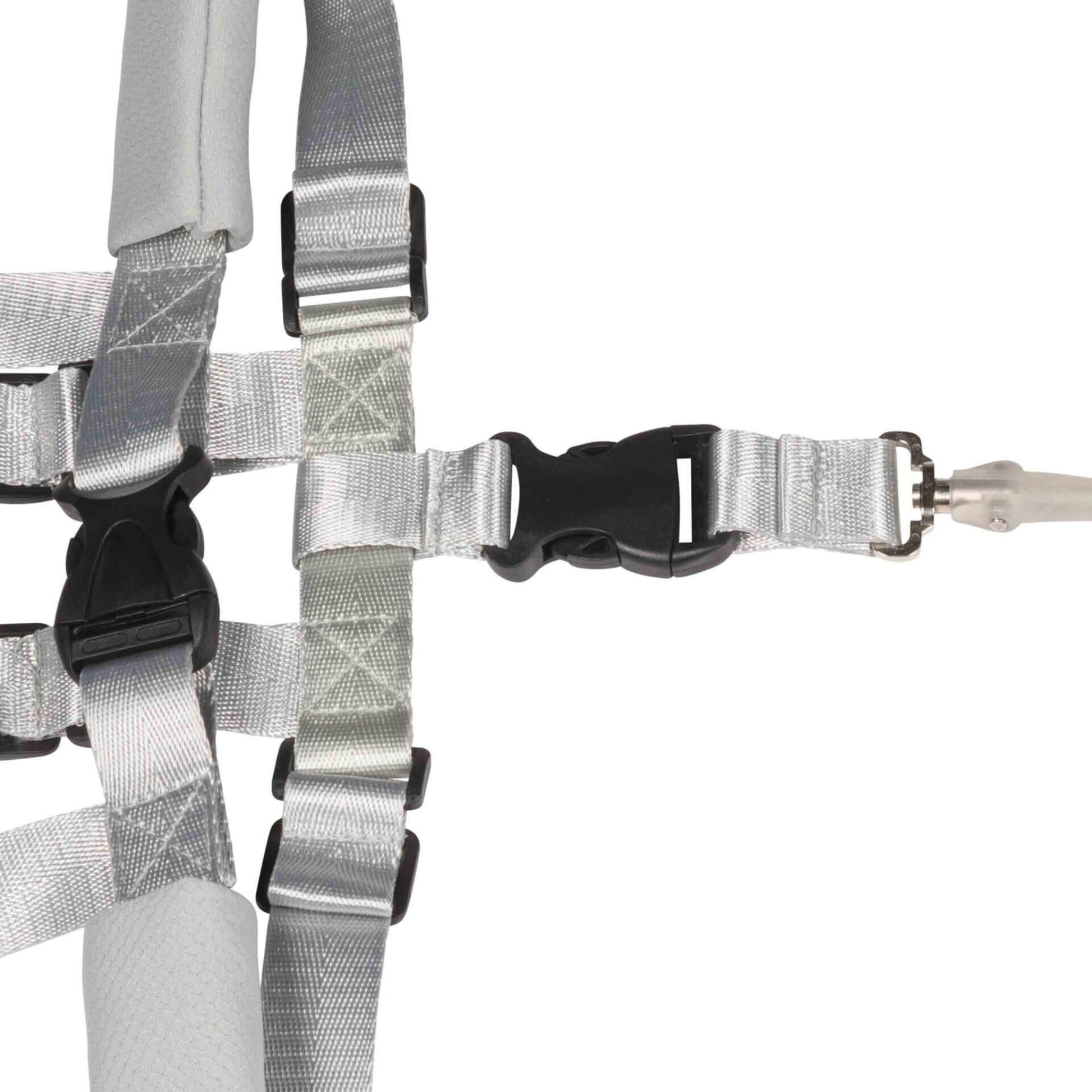 Close-up of the central buckle on a child safety harness, showing the connection point for the coiled tether.