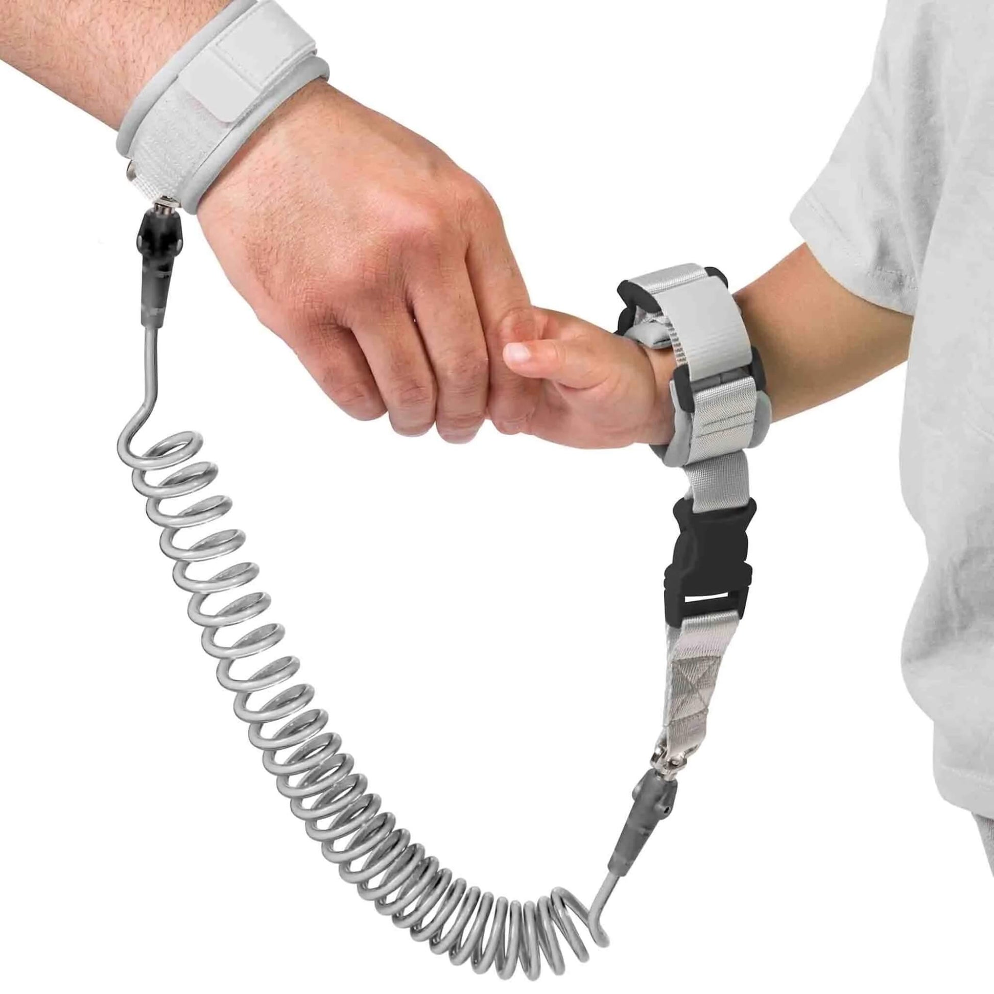 An adult hand and a child’s hand wearing padded wristbands connected by a coiled tether.