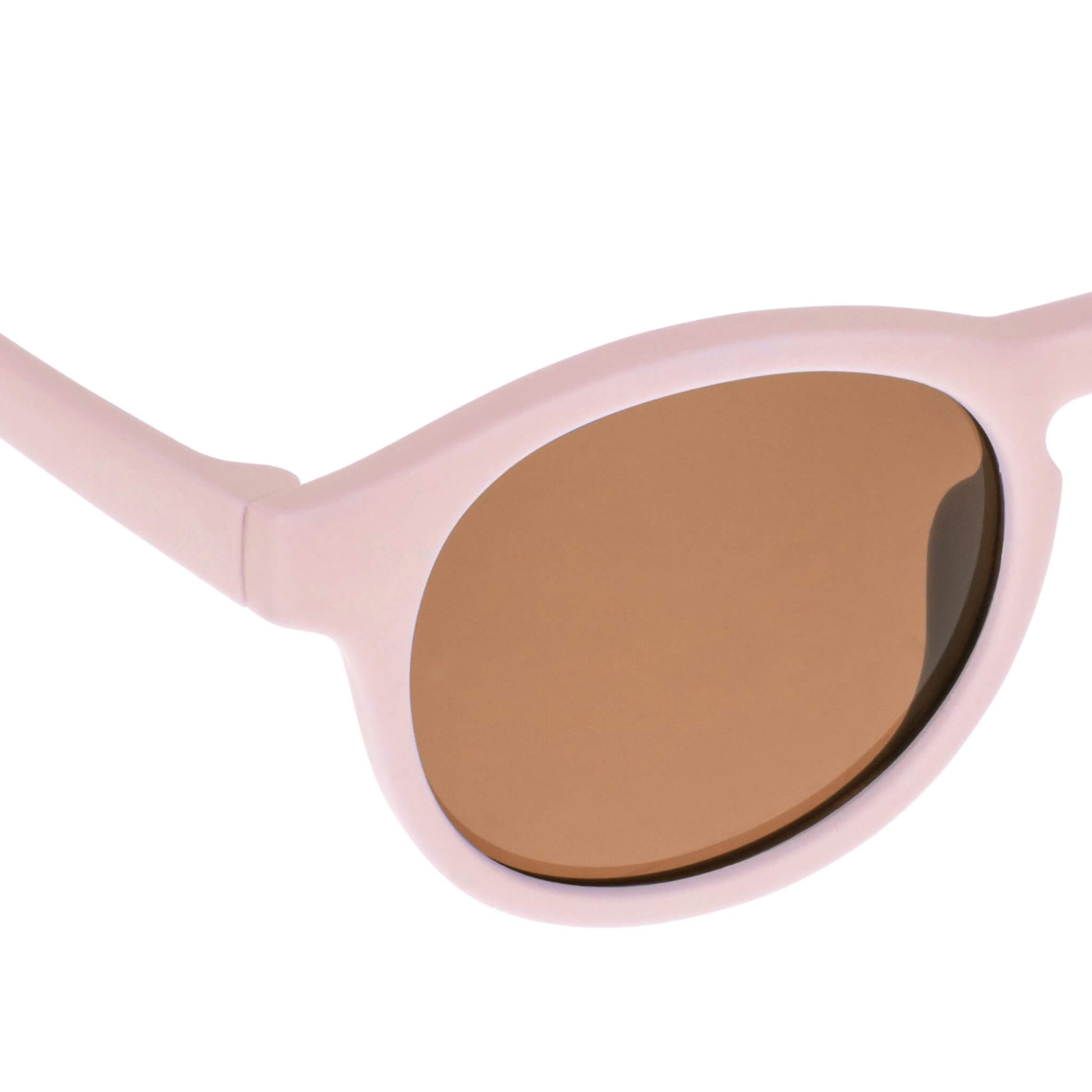 Close-up view of a Pink baby sunglasses lens showing scratch-resistant, anti-reflective brown coating.