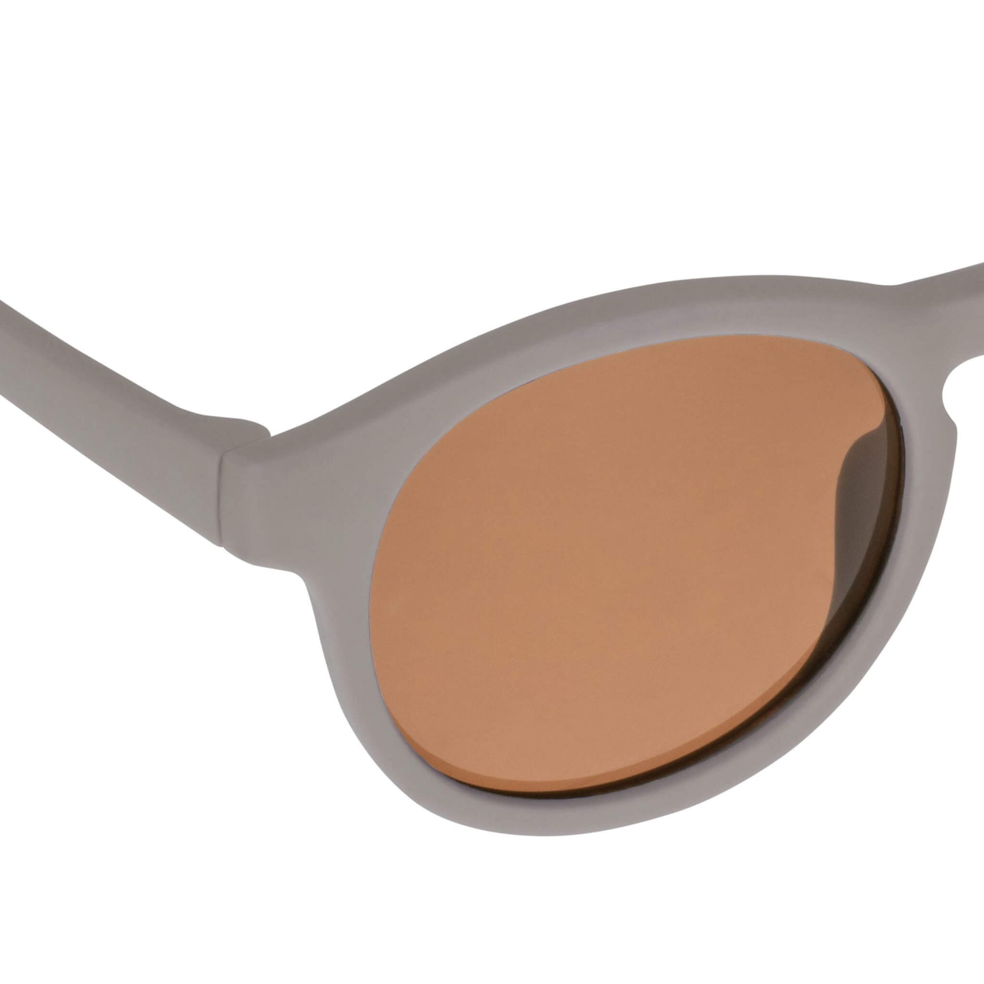 Close-up view of a taupe baby sunglasses lens showing scratch-resistant, anti-reflective brown coating.