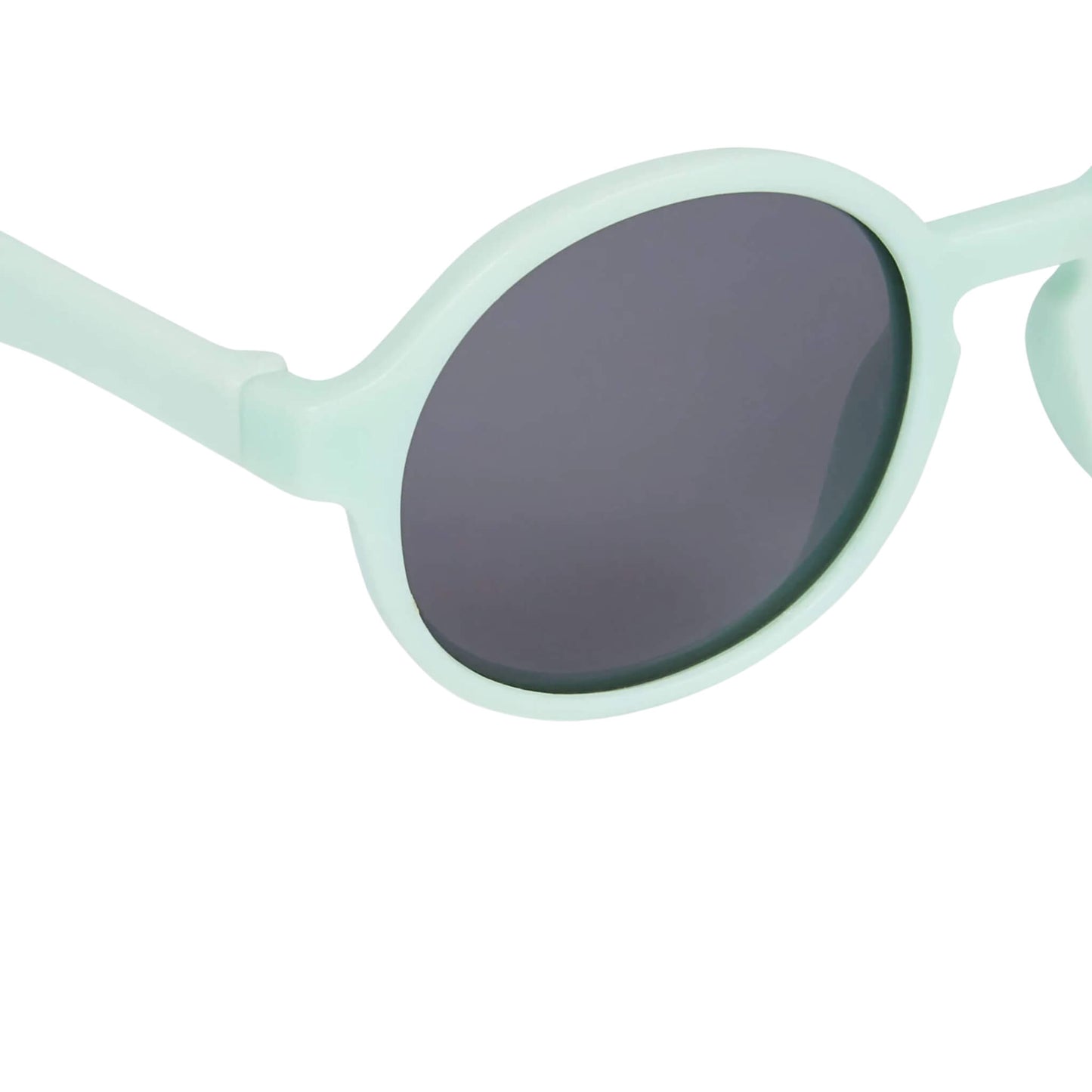 Close-up of one lens on a pair of mint toddler sunglasses, highlighting the smooth matte finish and scratch-resistant, dark-tinted lens.
