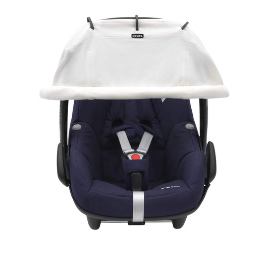 A cream sunshade with black rings attached to an infant car seat. The shade is rolled down and covers the top front area of the seat.