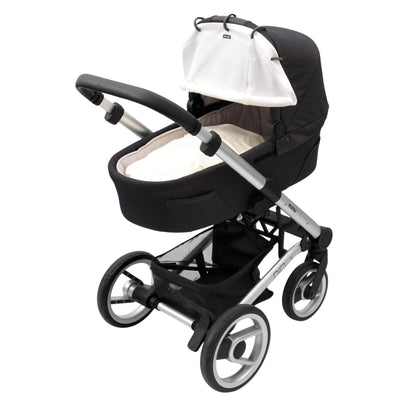 A cream sunshade fitted to a carrycot pram with black fabric and silver frame. The cover is partially rolled up and secured with Velcro.