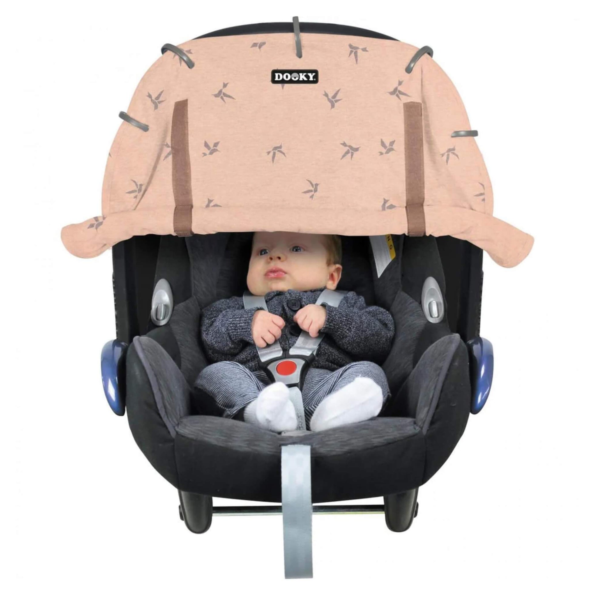 Dooky Sun Shade Origami Pink shown attached to a black infant car seat with a baby seated inside. The cover features a subtle origami bird print and is rolled down across the top.