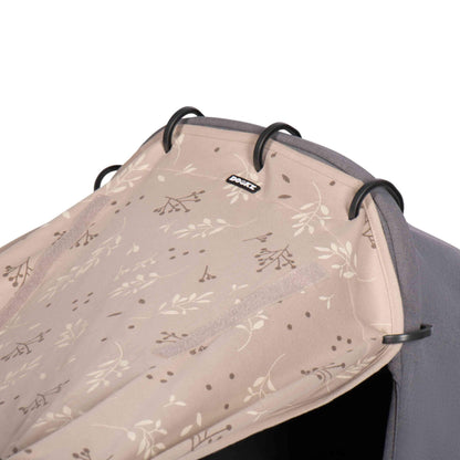 A close-up of the sunshade on a pram carrycot, showing its fabric texture, pattern, and attachment rings.