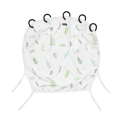 Dooky Sunshade in Tuscany with soft green leaf print, laid flat to show the five black attachment rings along the top and two fabric ties at the bottom.