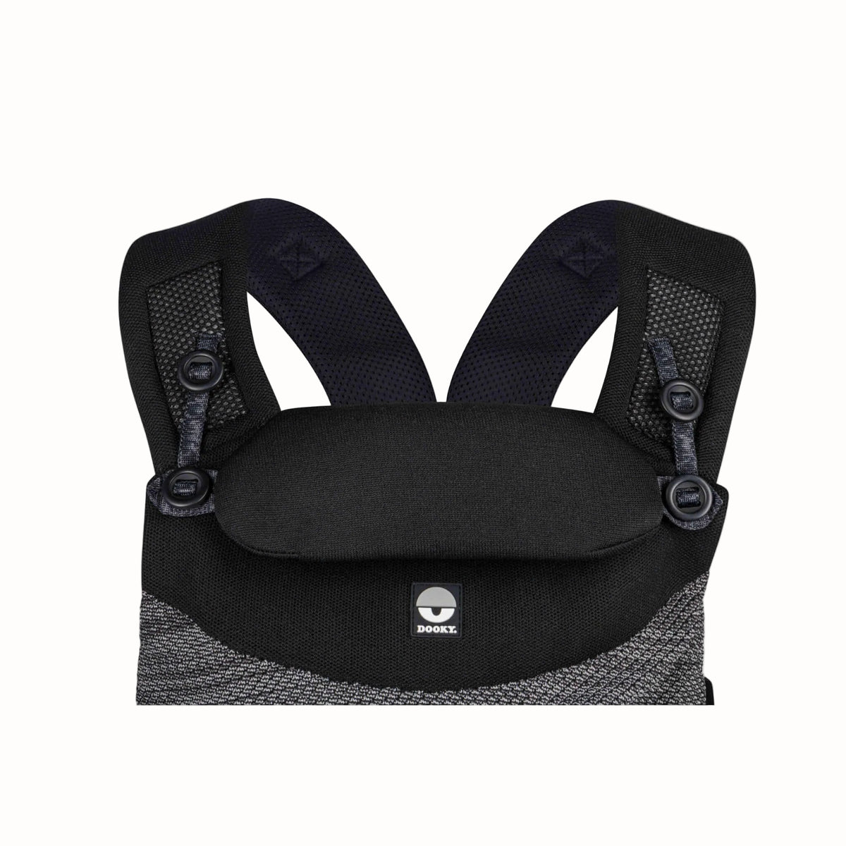 Close-up of a black baby carrier with the padded head support raised and adjustable shoulder straps visible.