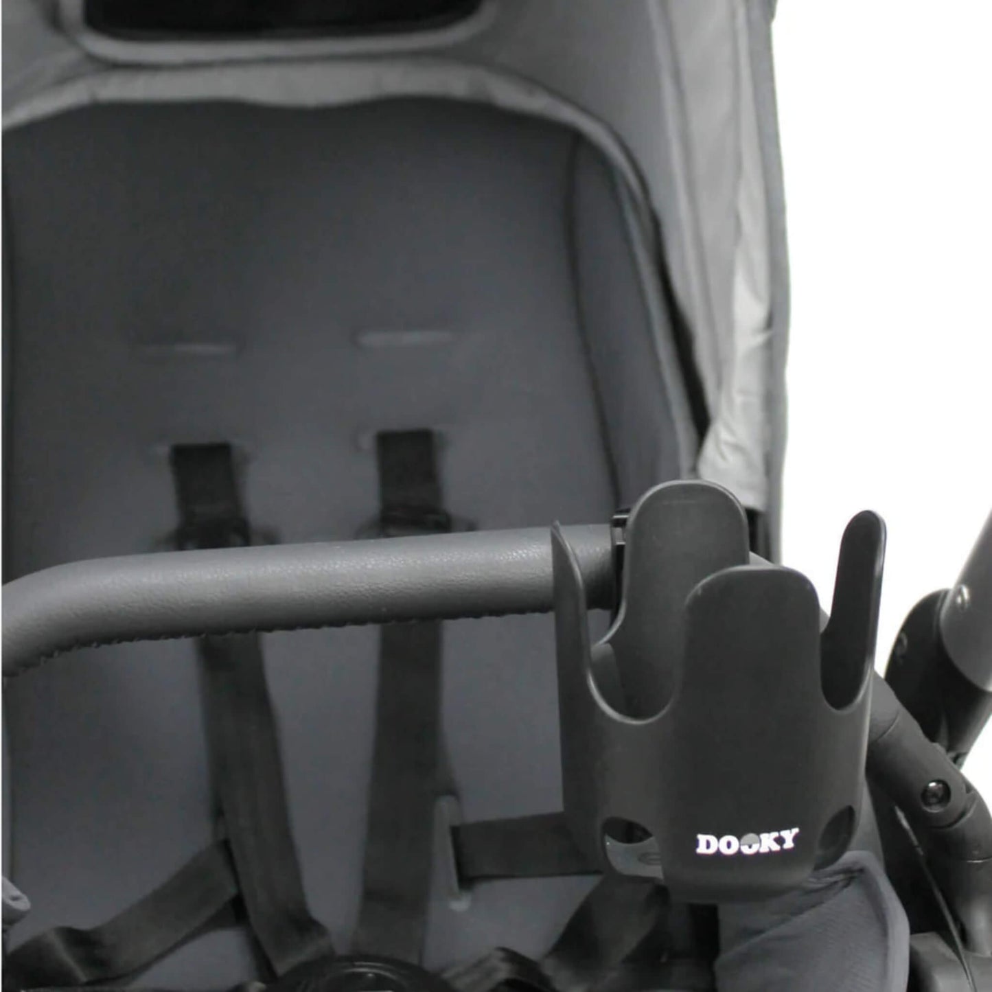 A black cup holder secured to the side of a stroller’s bumper bar in front of an empty seat.