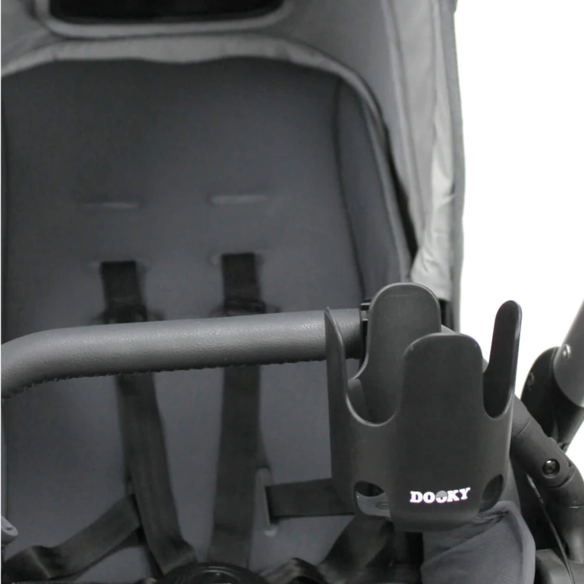 A black cup holder secured to the side of a stroller’s bumper bar in front of an empty seat.