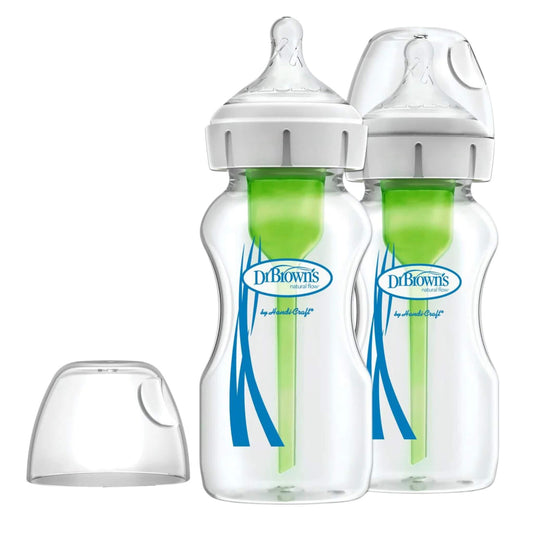 Two 270ml Dr Brown’s glass baby feeding bottles with green internal vent systems and clear protective caps, with one spare cap beside them on a white background.