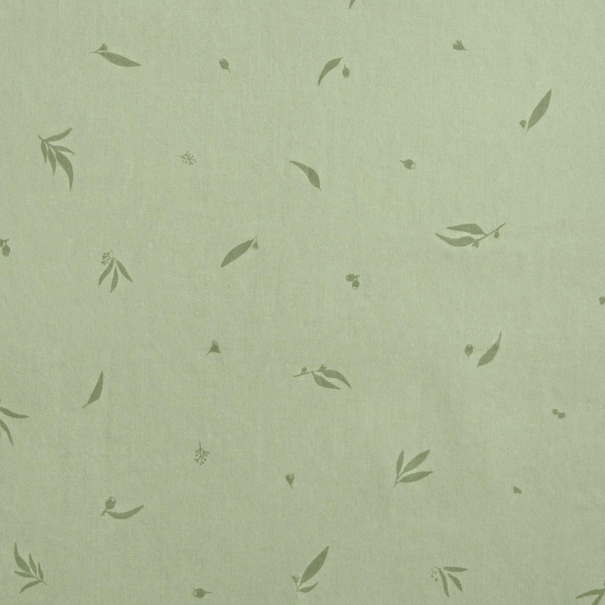 Close-up of soft green cotton fabric patterned with scattered leafy motifs, showing the Willow design print.