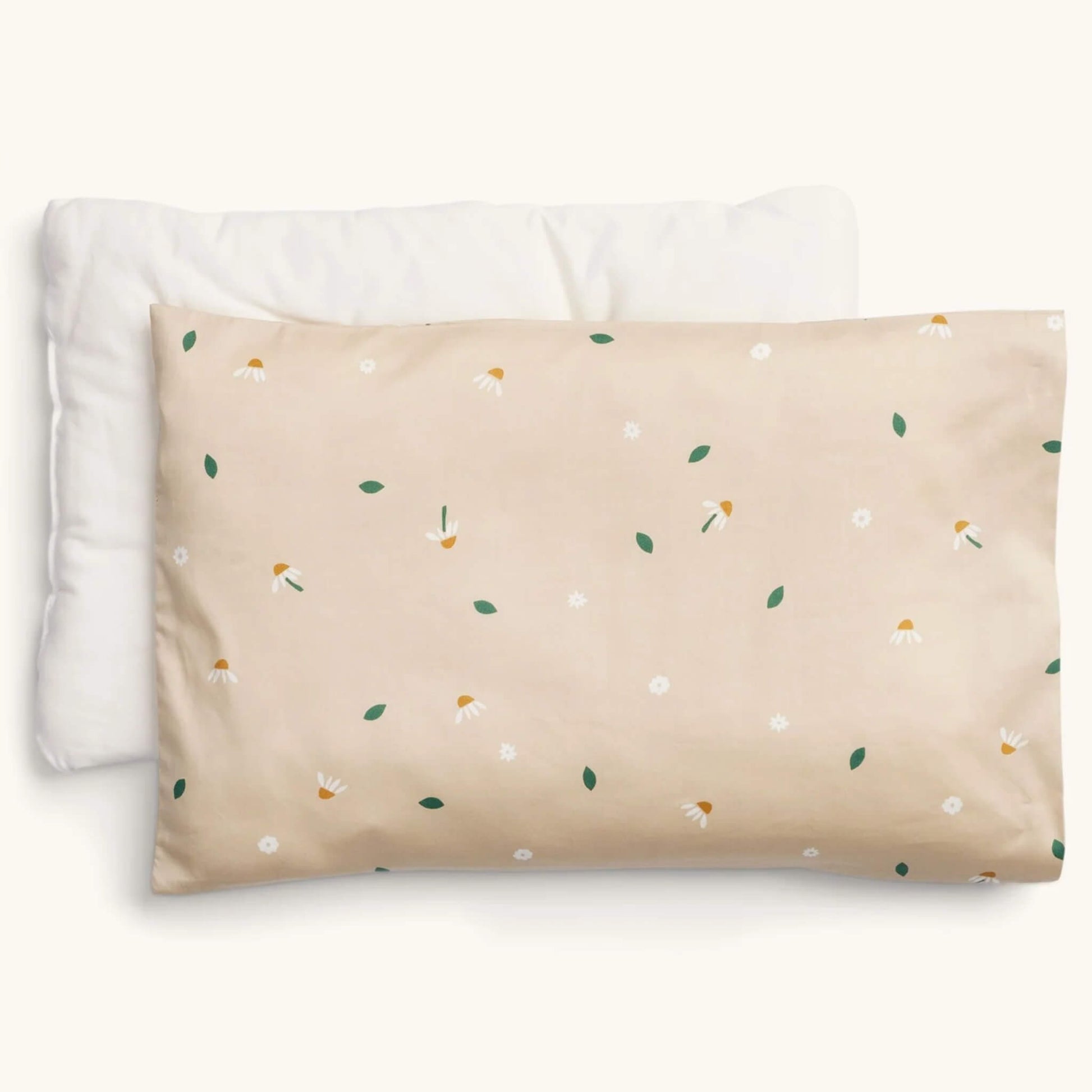 ErgoPouch Organic Toddler Pillow and Case in the Daisy Sprinkle print, showing a beige pillow with scattered white daisies and green leaves, displayed with its insert.