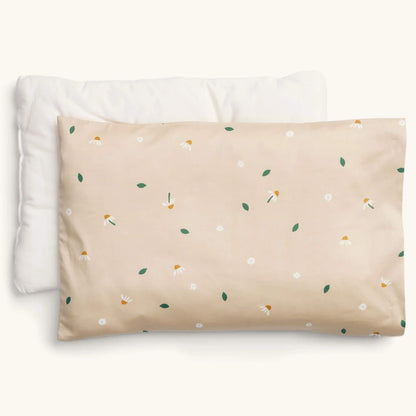 ErgoPouch Organic Toddler Pillow and Case in the Daisy Sprinkle print, showing a beige pillow with scattered white daisies and green leaves, displayed with its insert.