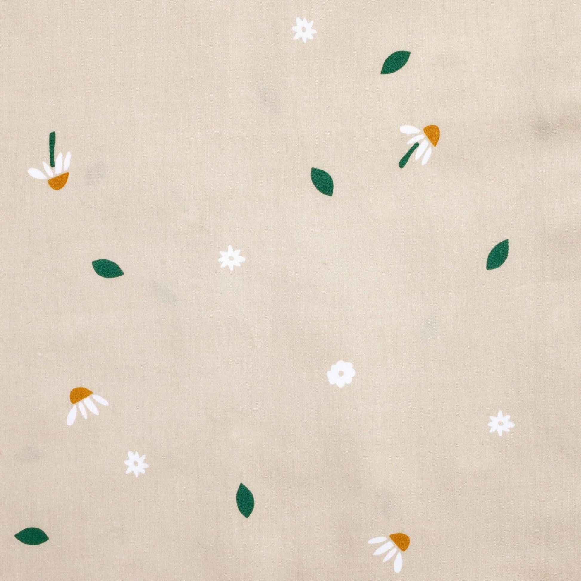 Close-up fabric view of the Daisy Sprinkle fabric print featuring scattered white daisies, golden centres, and green leaves on a beige background.