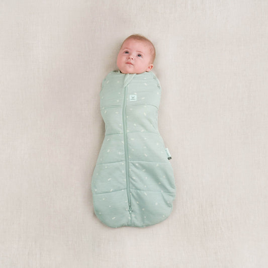 Baby in a winter weight 2.5 TOG cocoon swaddle bag, sage colour, organic and breathable fabric, perfect for keeping warm in colder weather.