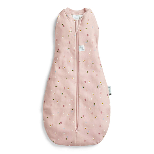 ErgoPouch Cocoon Swaddle Bag in a daisies print, featuring a soft pink fabric with delicate floral accents and a zip-up design.
