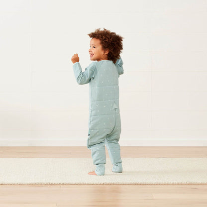 Toddler wearing a winter weight Sleep Onesie in sage green, showcasing the cosy quilted back and flexible fabric for comfortable movement.