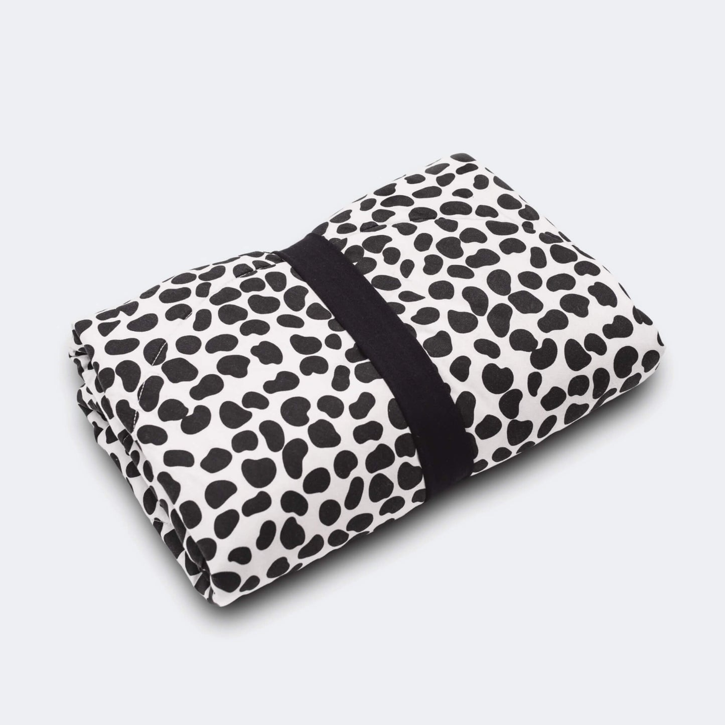 Folded round playmat secured with a black fabric strap, showing compact storage and travel friendly design.