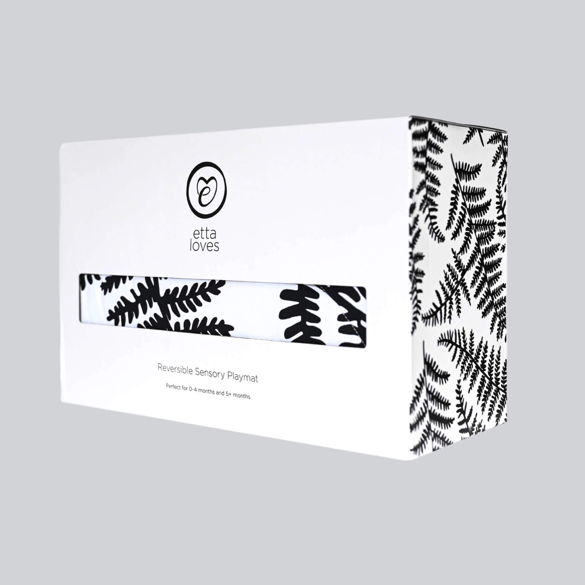 Branded cardboard product box with botanical print design and sensory playmat visible through front window.