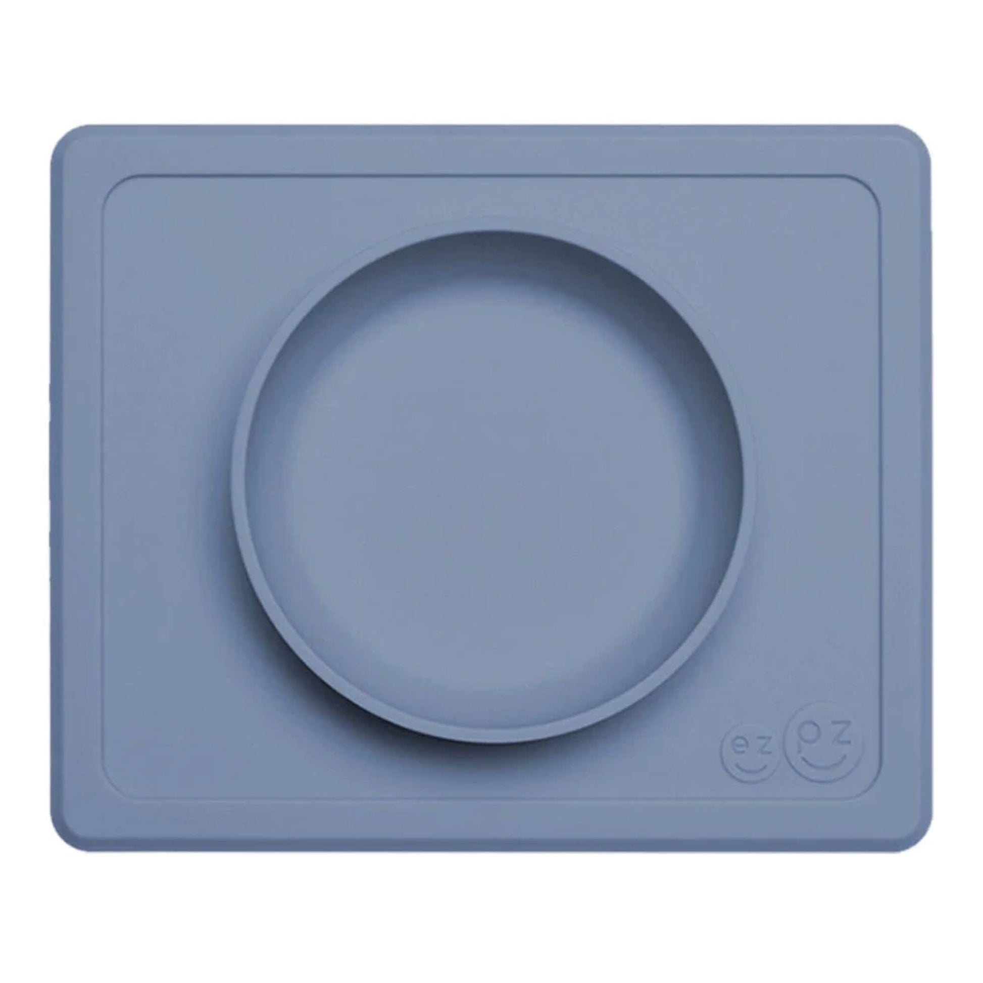 Indigo ezpz Mini Bowl shown from above, a silicone suction bowl built into a rectangular placemat to reduce spills during baby mealtimes.