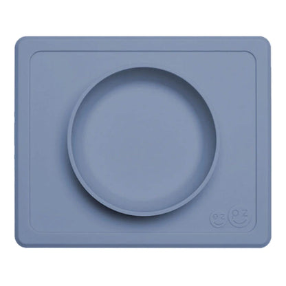 Indigo ezpz Mini Bowl shown from above, a silicone suction bowl built into a rectangular placemat to reduce spills during baby mealtimes.