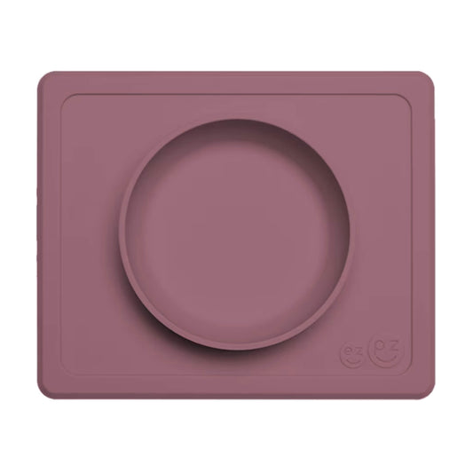 Mauve Mini Feeding Bowl shown from above, a silicone suction bowl built into a rectangular placemat to reduce spills during baby mealtimes.