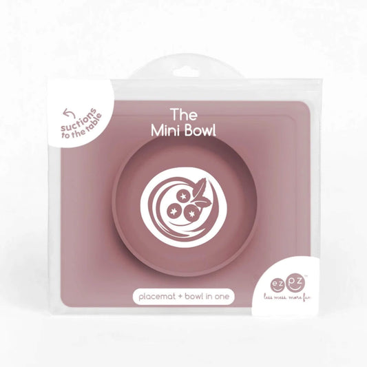 Mauve silicone mini suction bowl with built-in placemat, shown inside retail packaging with clear front display.