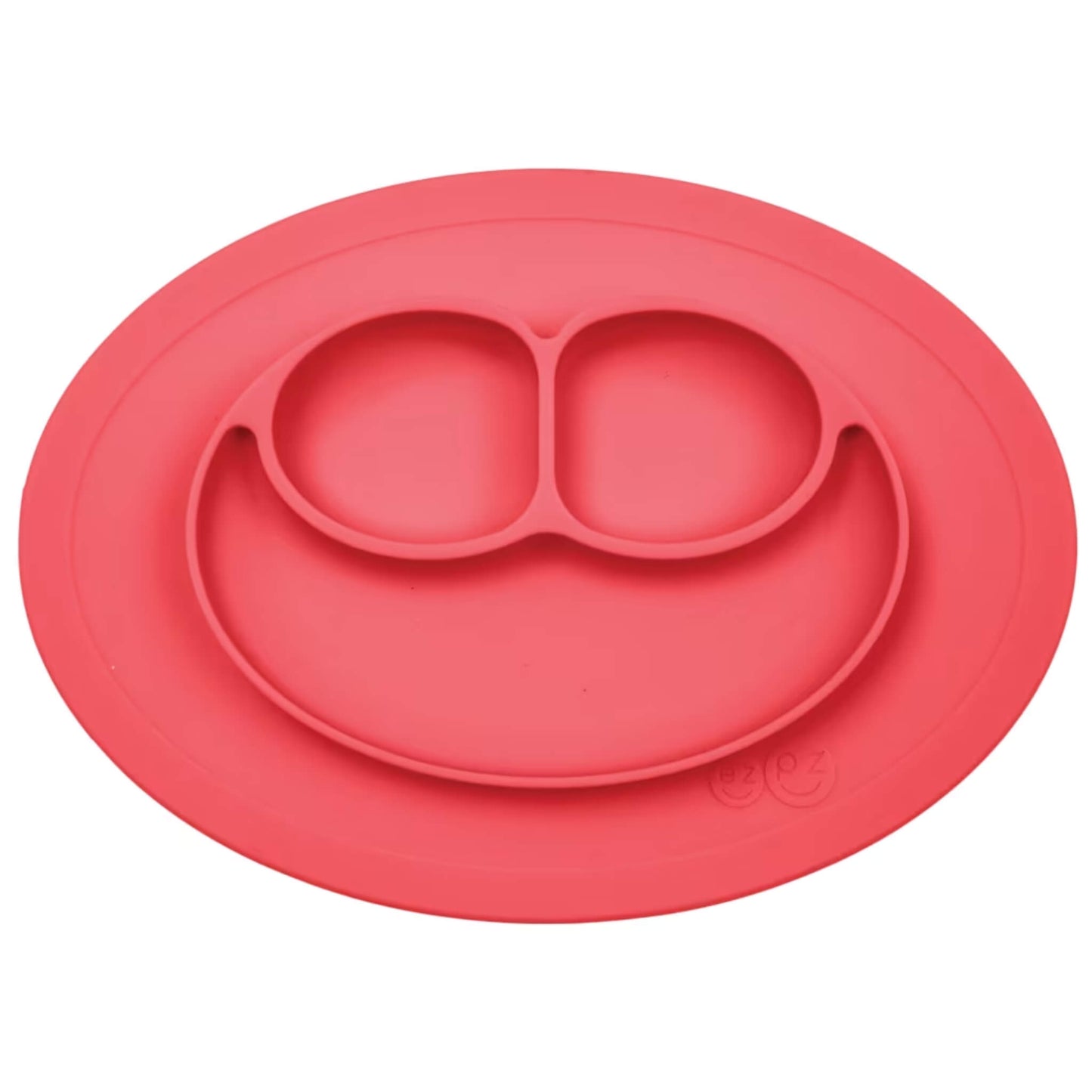 Ezpz Mini Mat in coral silicone, an all-in-one suction placemat and baby plate with three divided sections arranged in a smile design