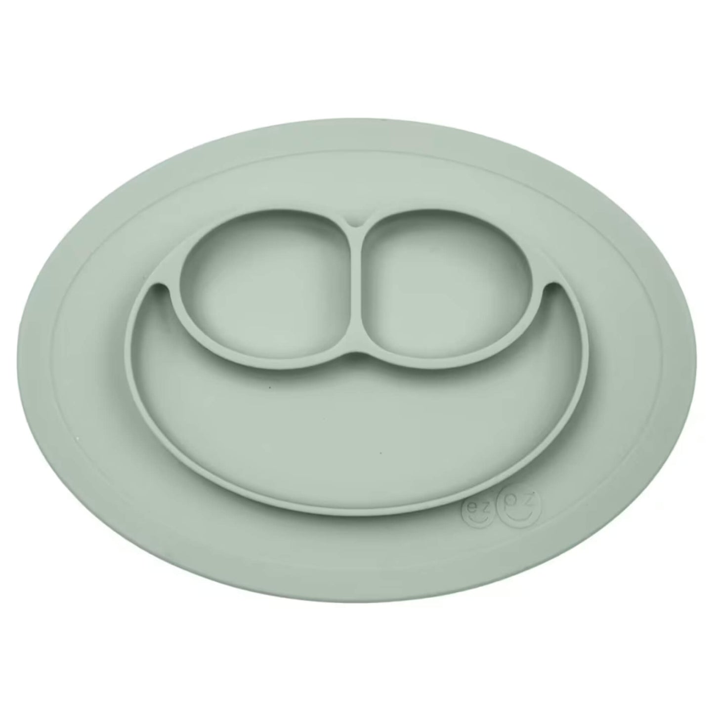 Ezpz Mini Mat in sage green silicone, an all-in-one suction placemat and baby plate with three divided sections arranged in a smile design.