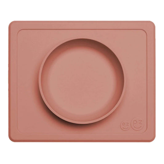 ezpz Mini Bowl in sienna with a square silicone placemat and raised central bowl, shown empty from above.