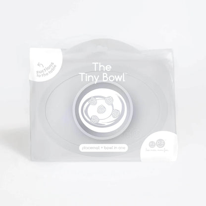 Retail packaging of a Tiny Bowl in pewter with product illustration of raspberries inside the bowl and text reading placemat + bowl in one.