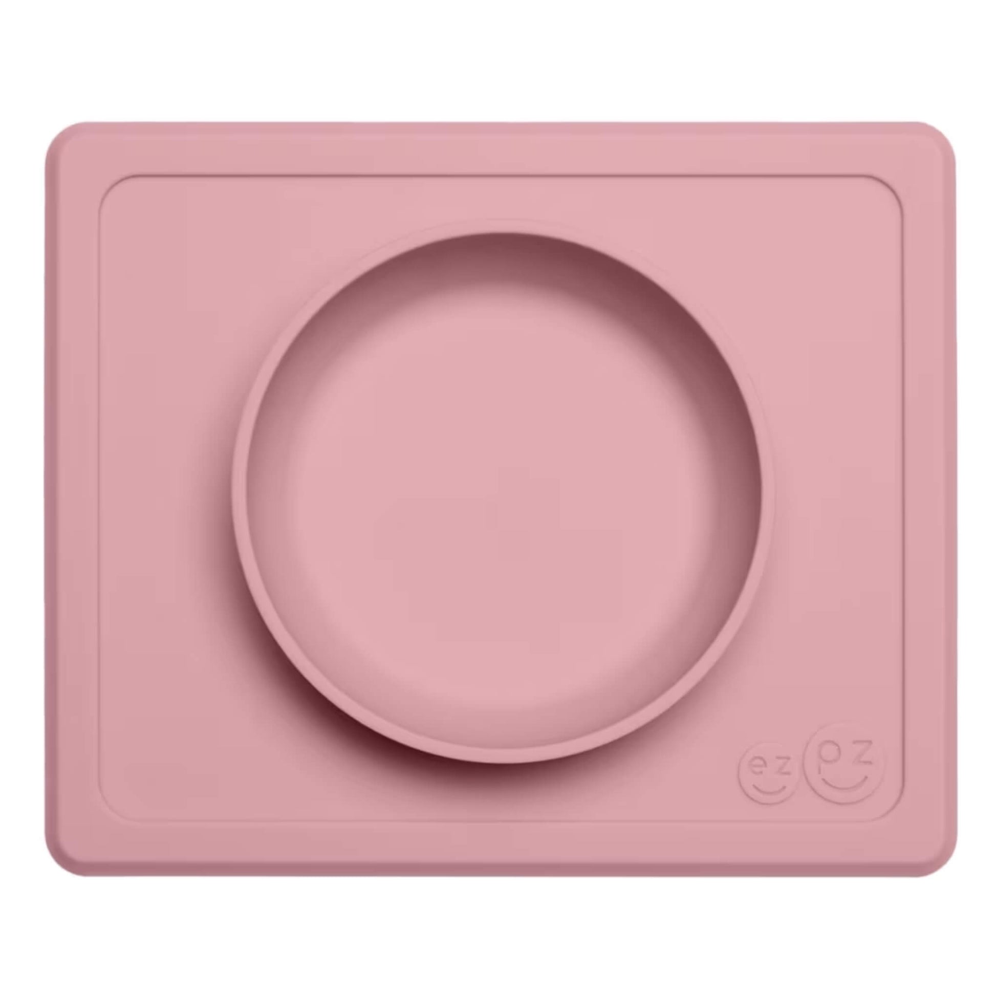 Ezpz Mini Bowl in blush pink, a silicone placemat and bowl in one that suctions to the table to reduce spills during toddler mealtimes.