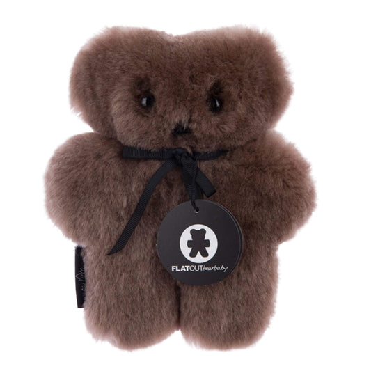 FLATOUTbear Baby comfort toy made from 100% Australian sheepskin, shown in chocolate brown with a flat teddy shape, stitched facial features and hanging brand tag.