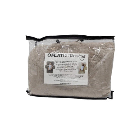 A bear-shaped sheepskin baby play rug folded inside a clear zip storage bag with product label visible on the front.