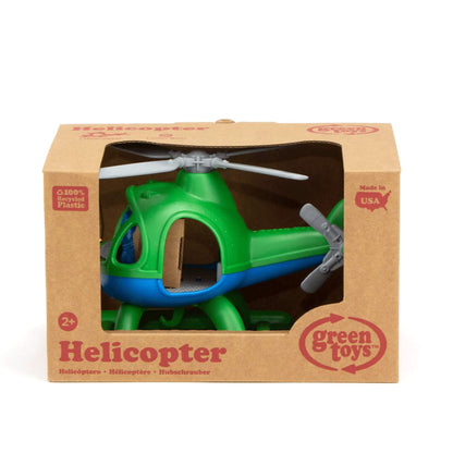 Green and blue helicopter displayed inside its cardboard packaging, with rotors visible through the cutout window and branding on the front.