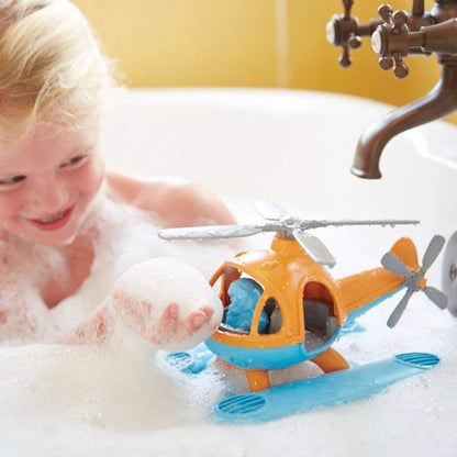 Child playing in a bubble bath, smiling at the Seacopter floating on the water with the blue bear pilot inside the cockpit.