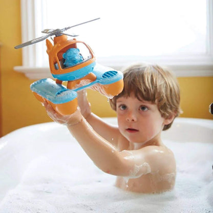 Young boy lifting the Seacopter out of the bath with both hands, water dripping from the pontoons as he inspects the toy.