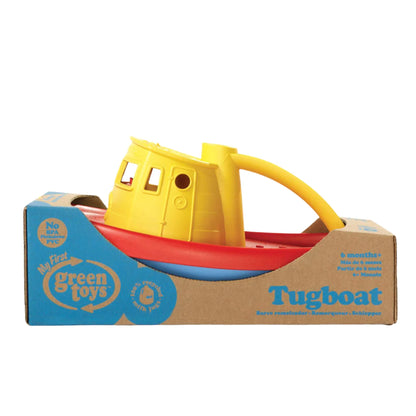 The tugboat is displayed inside its cardboard packaging, with product information and branding clearly visible on the box.
