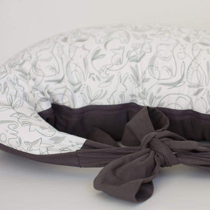 Close-up of a feeding pillow 'animal friends' fabric showing grey underside and knotted cotton ties for secure fastening.