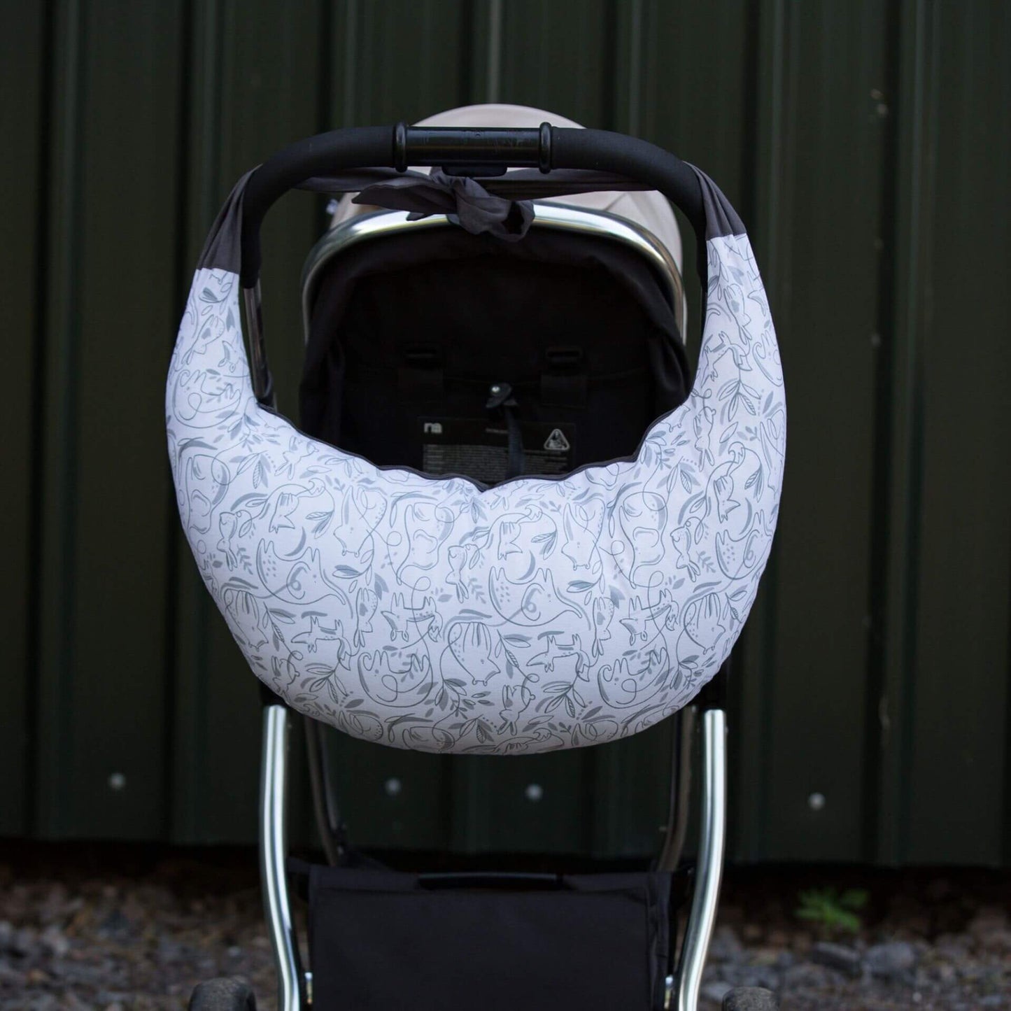 A feeding pillow tied over pushchair handle for convenient carrying when out and about.