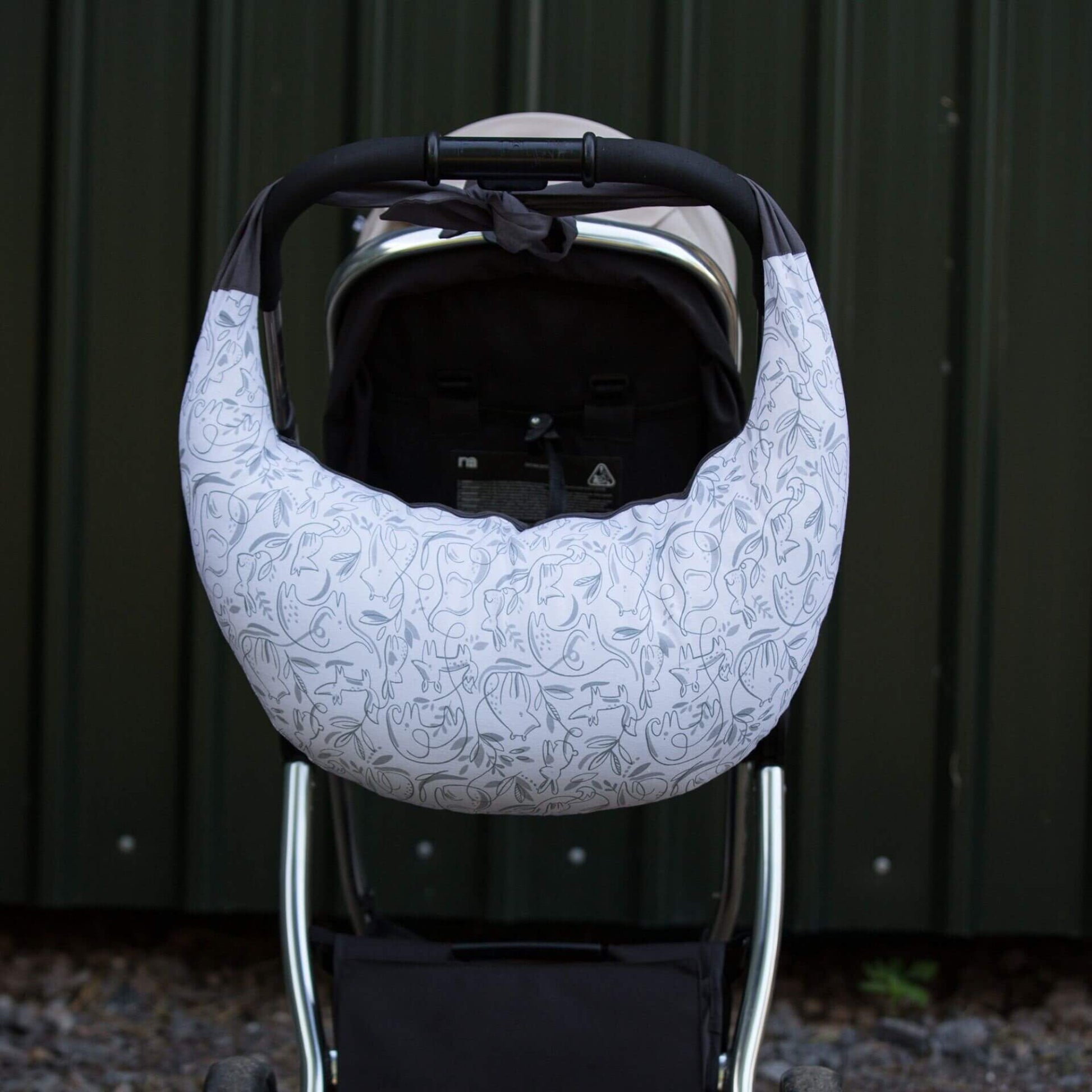 A feeding pillow tied over pushchair handle for convenient carrying when out and about.