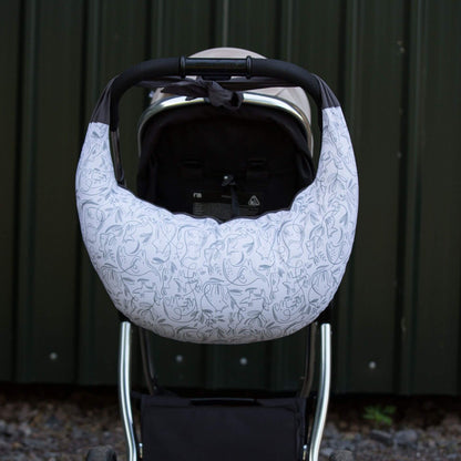 A feeding pillow tied over pushchair handle for convenient carrying when out and about.